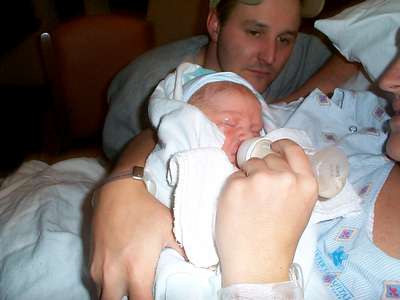 Mommy gets the first feeding with Daddy looking on.